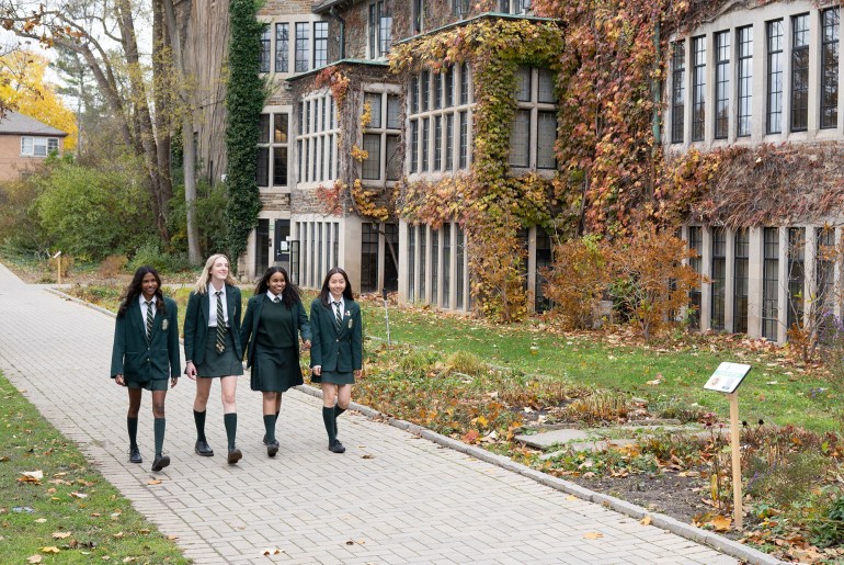 Students walking down an outdoor path next to the Upper School.
