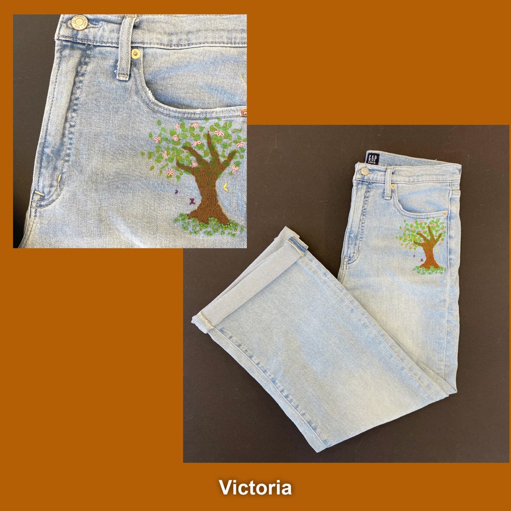 Jeans with a tree embroidered on them.