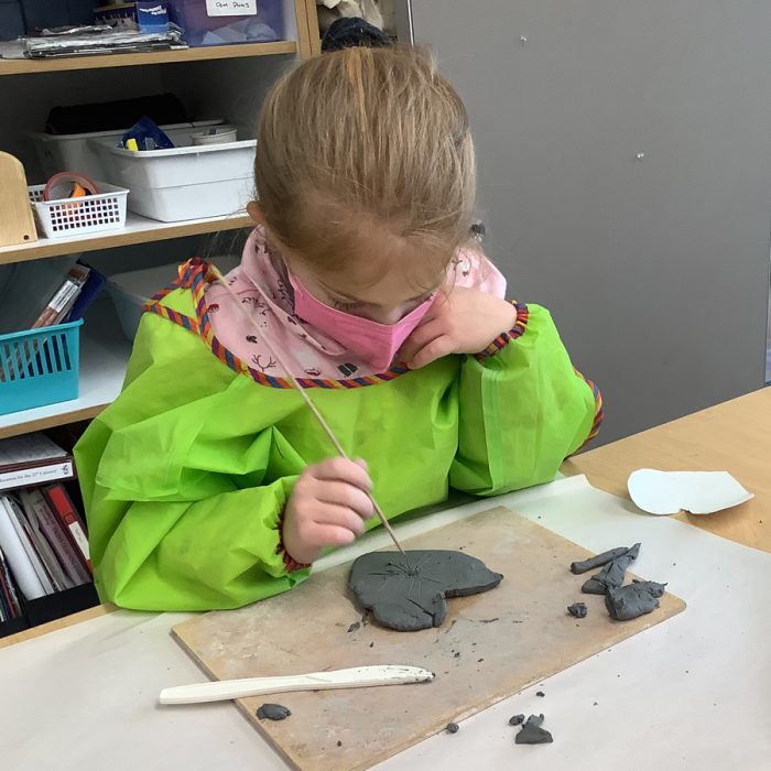 Student making a clay heart.