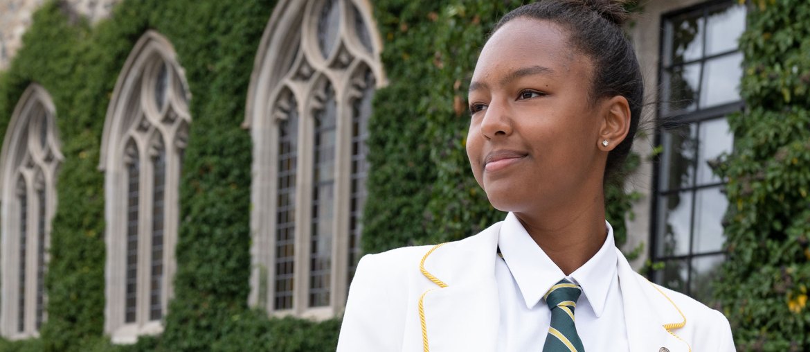 2021-22 School Captain in front of the Upper School.