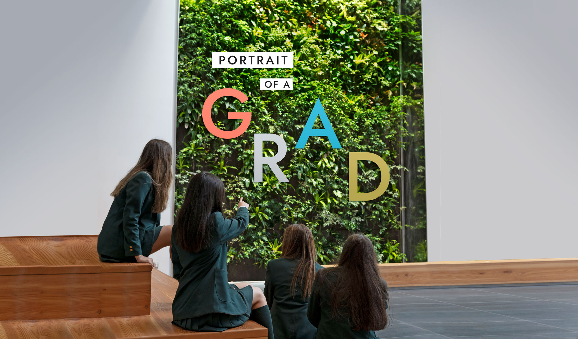 Students looking at the BioWall with the words "Portrait of a Grad" written on it.