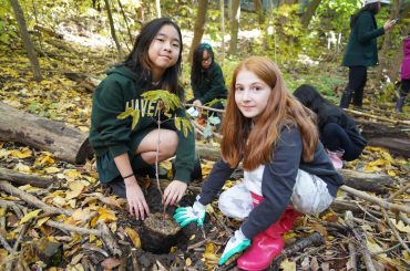 Students plant trees in the Lisa Hardie Woodland Trail.