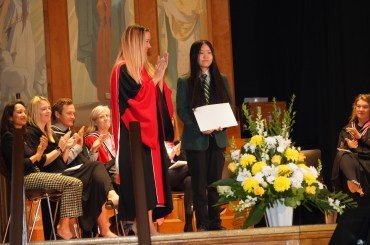 Havergal's Principal on stage applauding a student award winner.