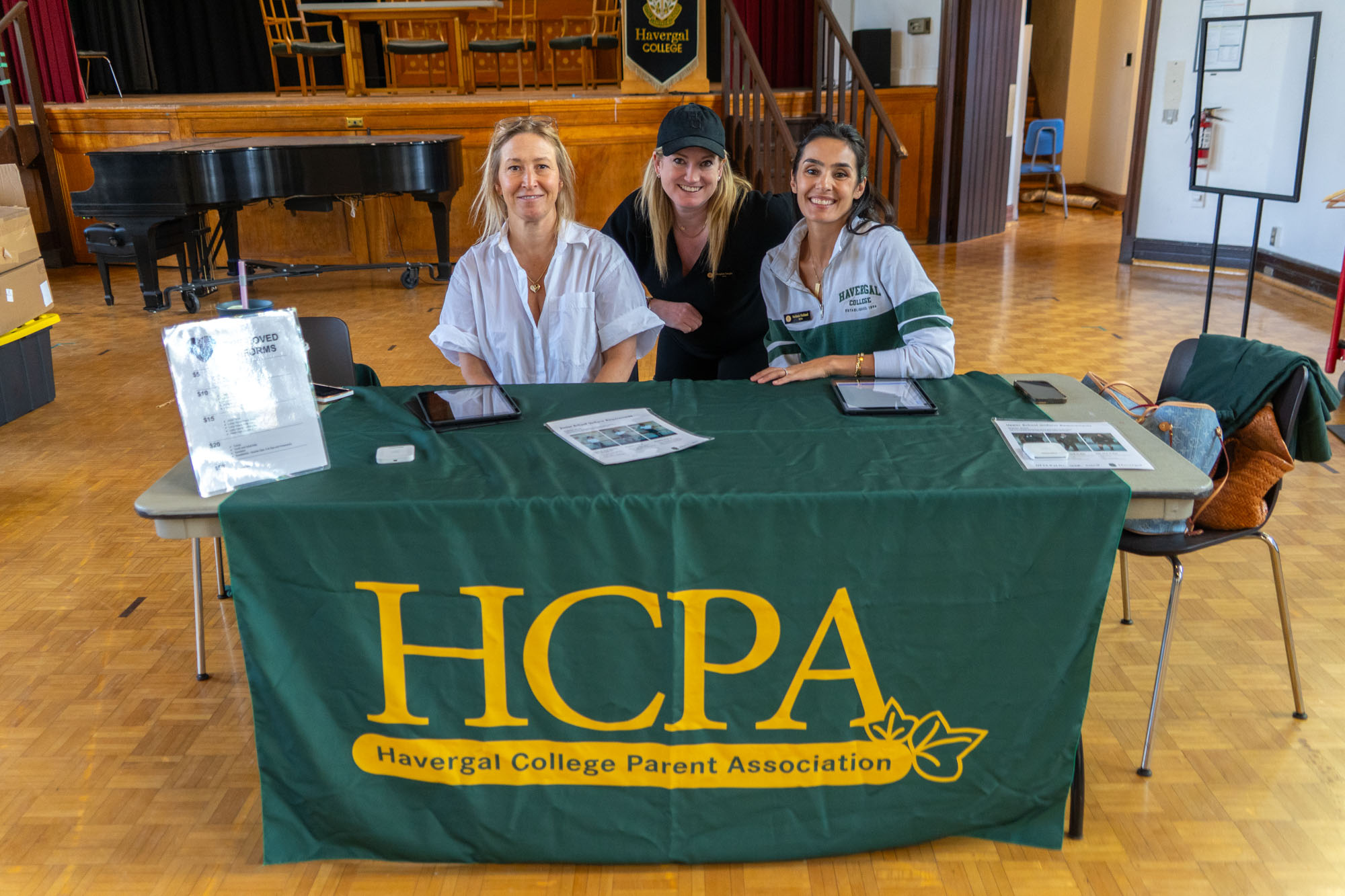 HCPA volunteers sitting at a table with an HCPA table cloth.