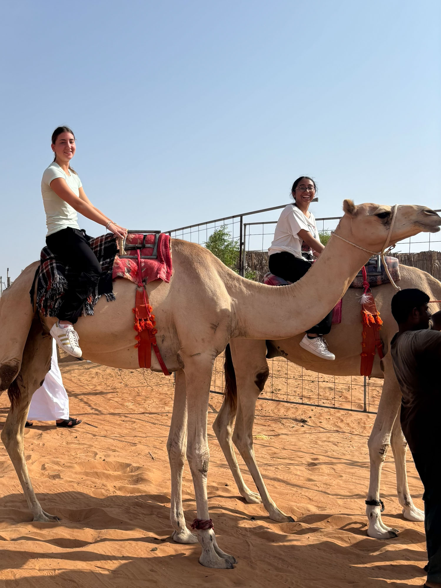 Audrey riding a camel with a friend.