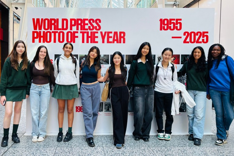 Students in front of a sign that says "World Press Photos of the Year 1955-2025."